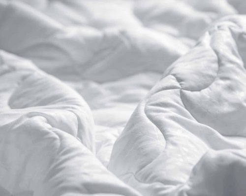 White blanket. Wrinkle messy blanket  in bedroom after waking up in the morning. Bed details. Duvet and blanket, an unmade bed in hotel bedroom with white blanket. Messy White Bed.